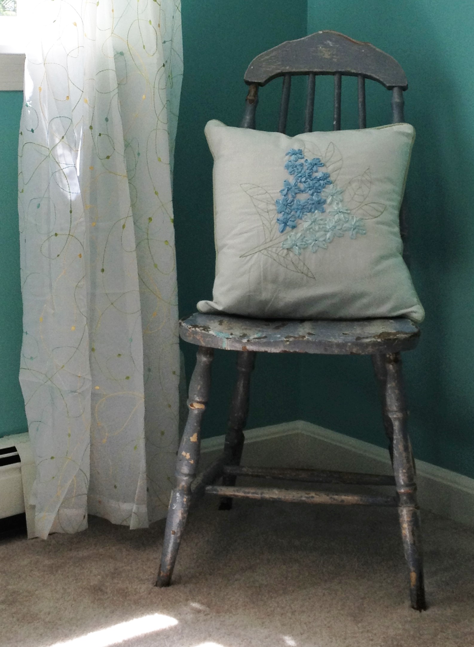 photo of vintage paint chipped chair with pillow