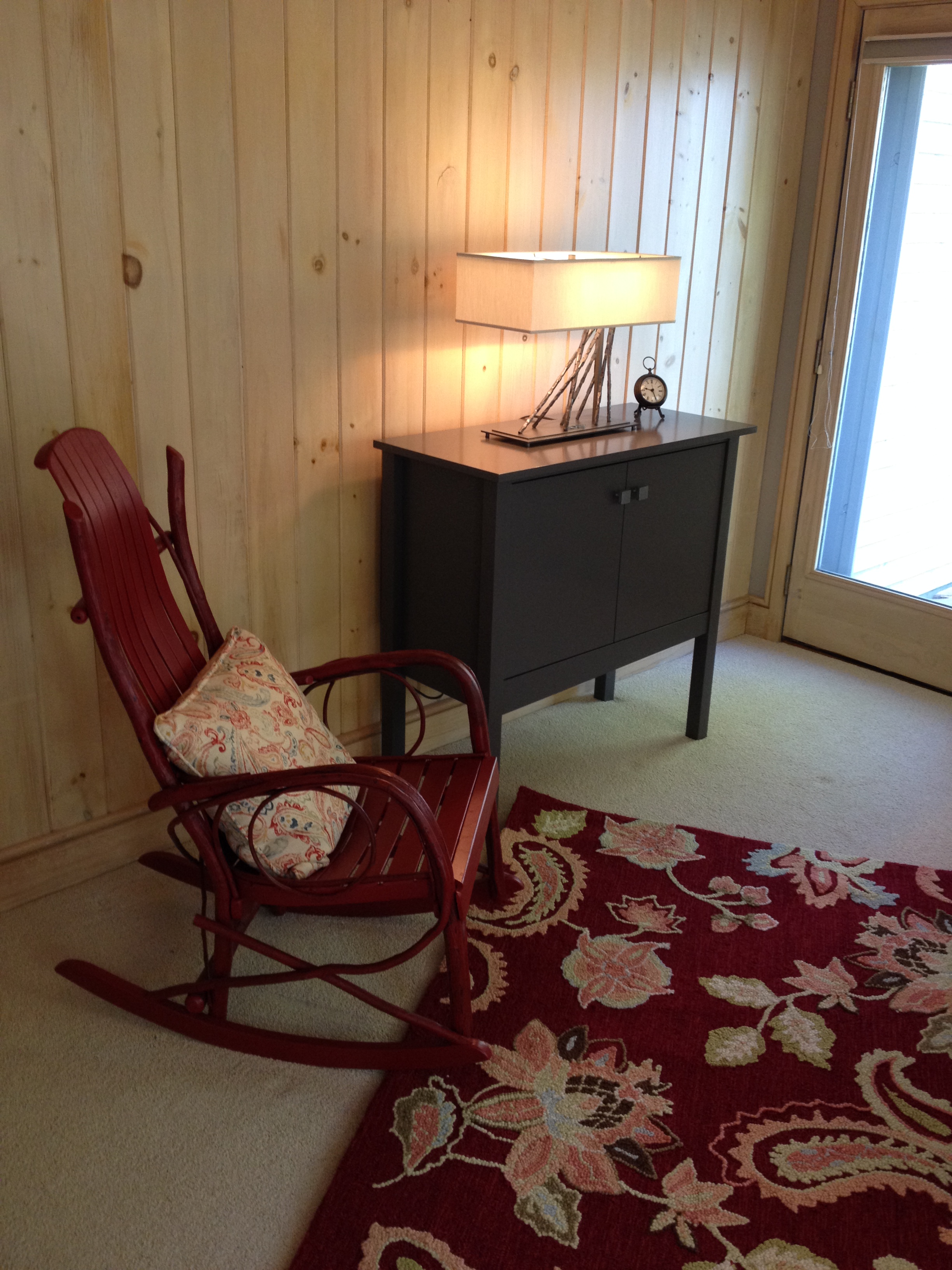 Photo of rocker, area rug, table lamp and custom cabinet